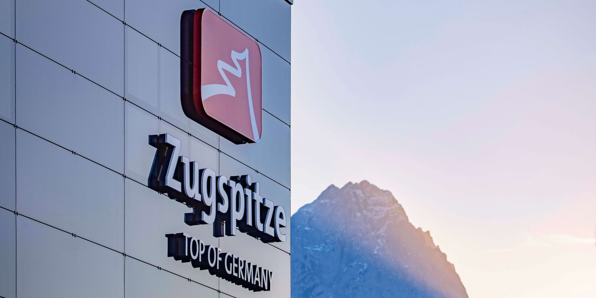 Bayerische Zugspitzbahn Logo Neubau, Berg im Hintergrund